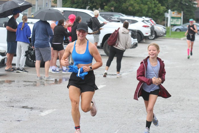 A woman and a girl run in the 2026 South Huron Trail Run.
